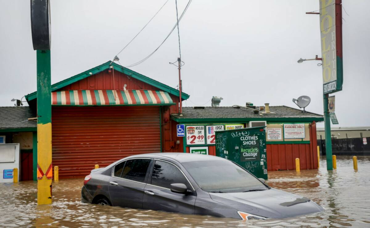 Floodwater from a breached levee submerges cars and floods businesses on Salinas Road in Pajaro ...