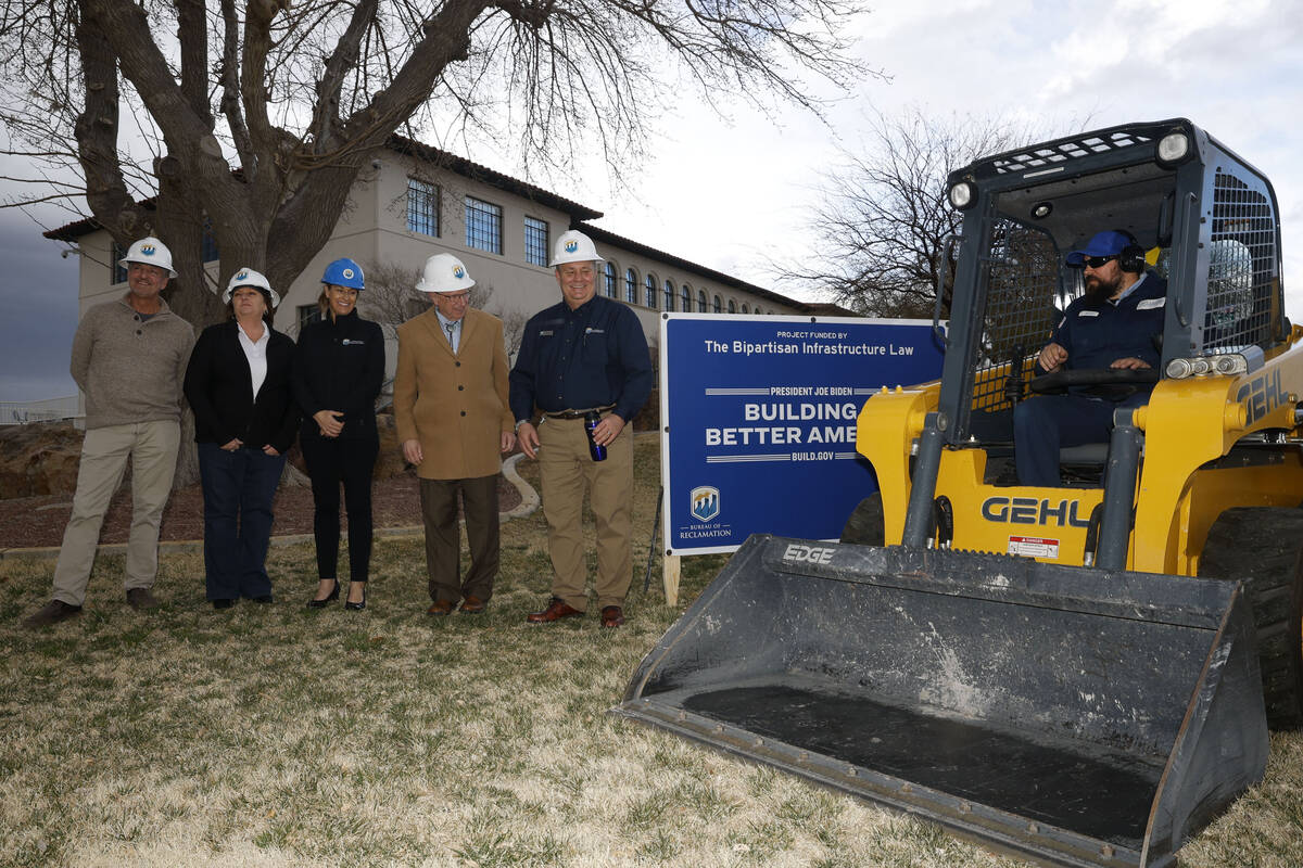Joel Dunbar of the Bureau of Reclamation, right, operates a skid steer to remove the grass as t ...