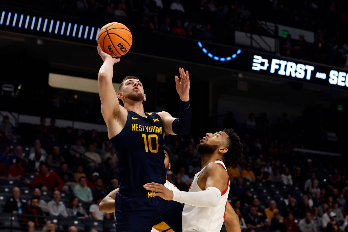 West Virginia guard Erik Stevenson (10) shoots over Maryland guard Don Carey (0) in the first h ...
