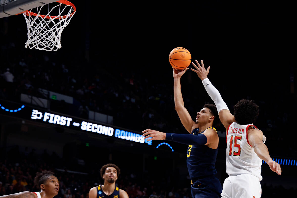 West Virginia forward Tre Mitchell (3) puts up a shot as Maryland forward Patrick Emilien (15) ...