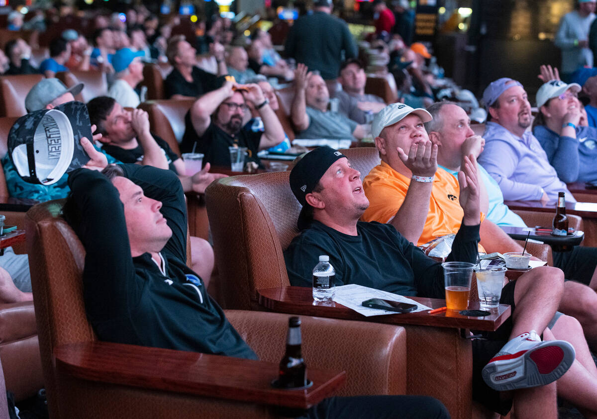 Guests watch on the big screens during the first day of the NCAA basketball tournament at the W ...
