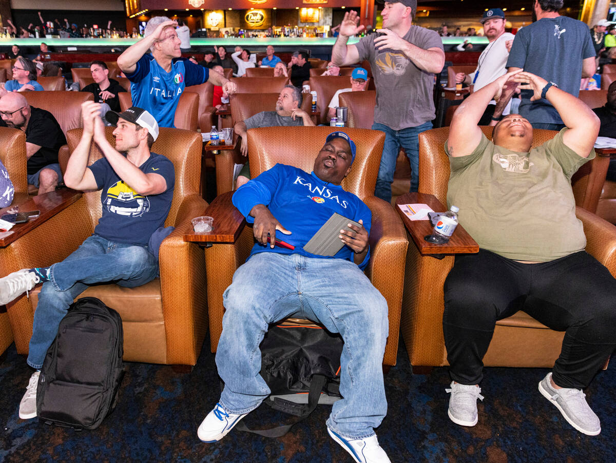 Brian Twining, left, Quine Gilber and Antron Stacks, right, react to a play as they watch on th ...