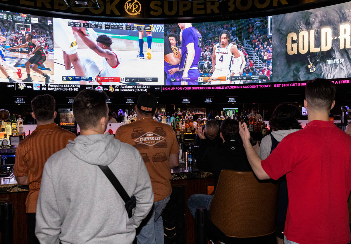 Guests watch on the big screens the first day of the NCAA basketball tournament at the Westgate ...