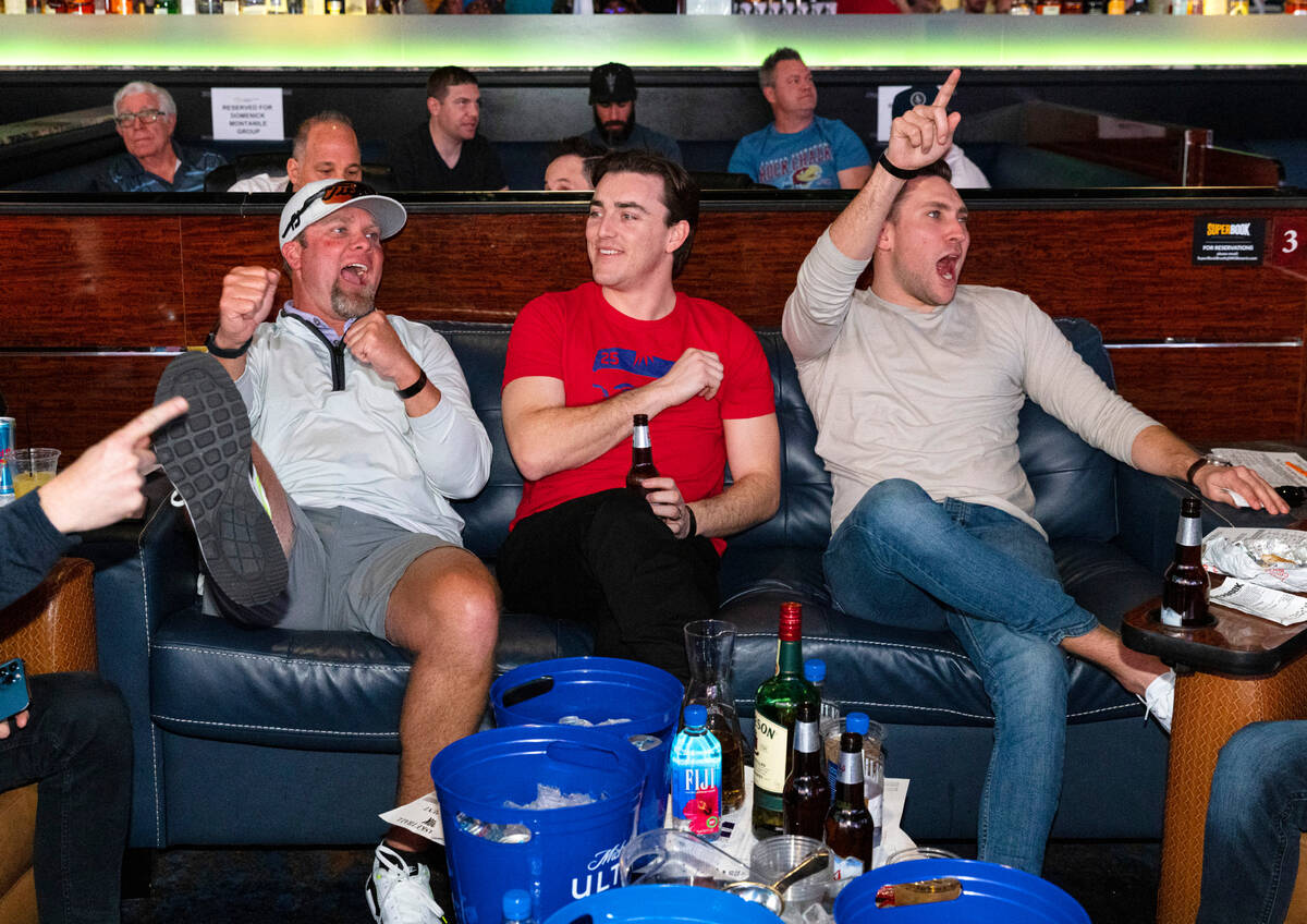 Tray Schurr, left, Ty Fracchia, and Andrew Masey, all of Texas, react to a play as they watch o ...