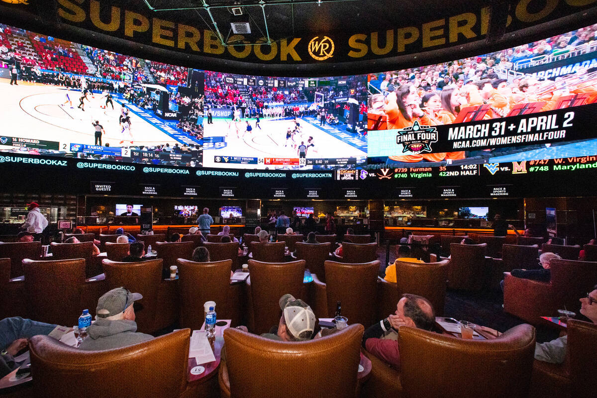 Guests watch on the big screens the first day of the NCAA basketball tournament at the Sports B ...