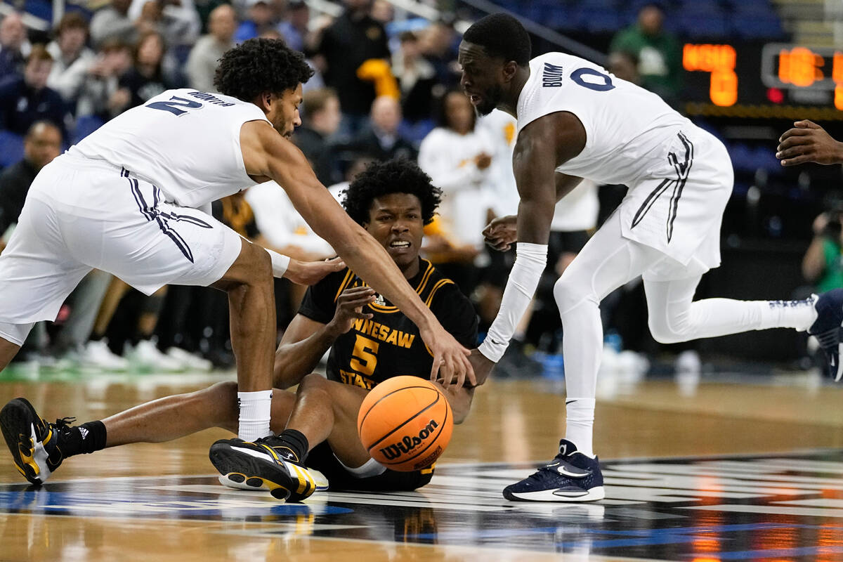 Kennesaw State's Brandon Stroud (5) battles Xavier's Jerome Hunter (2) and Souley Boum (0) for ...