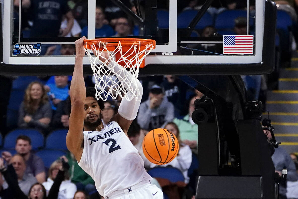 Xavier's Jerome Hunter scores during the first half of a first-round college basketball game ag ...