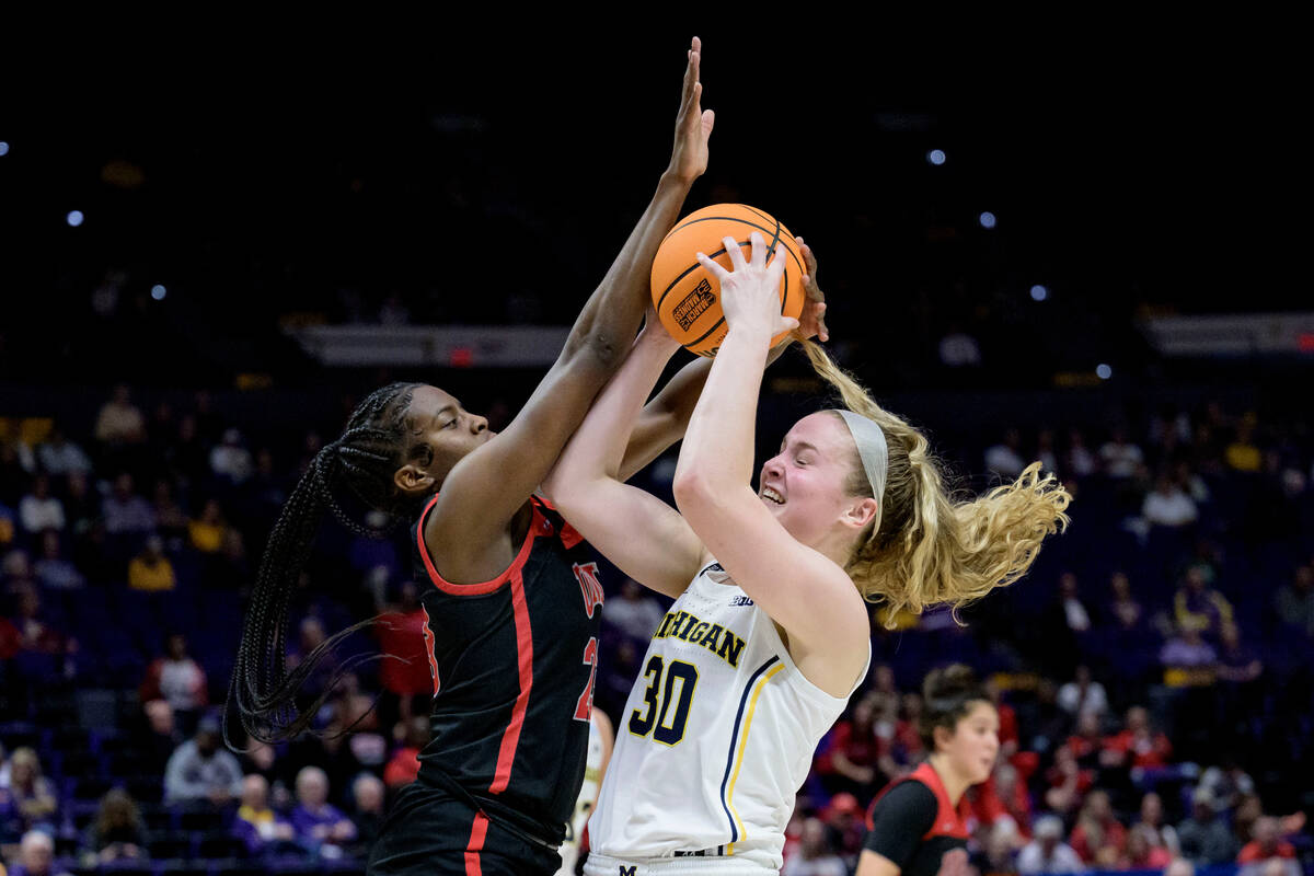 Michigan guard Elise Stuck (30) shoots against UNLV center Desi-Rae Young, left, in the second ...