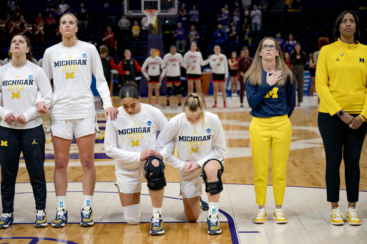 Michigan forward Cameron Williams, center left, and guard Maddie Nolan, center right, take a kn ...