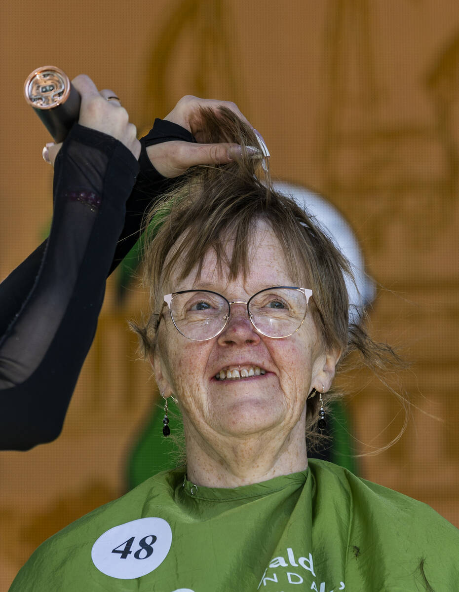 Fundraiser Karen Cyr of Kalamazoo, MI, has the first of her long hairs shaved off by stylist Ab ...
