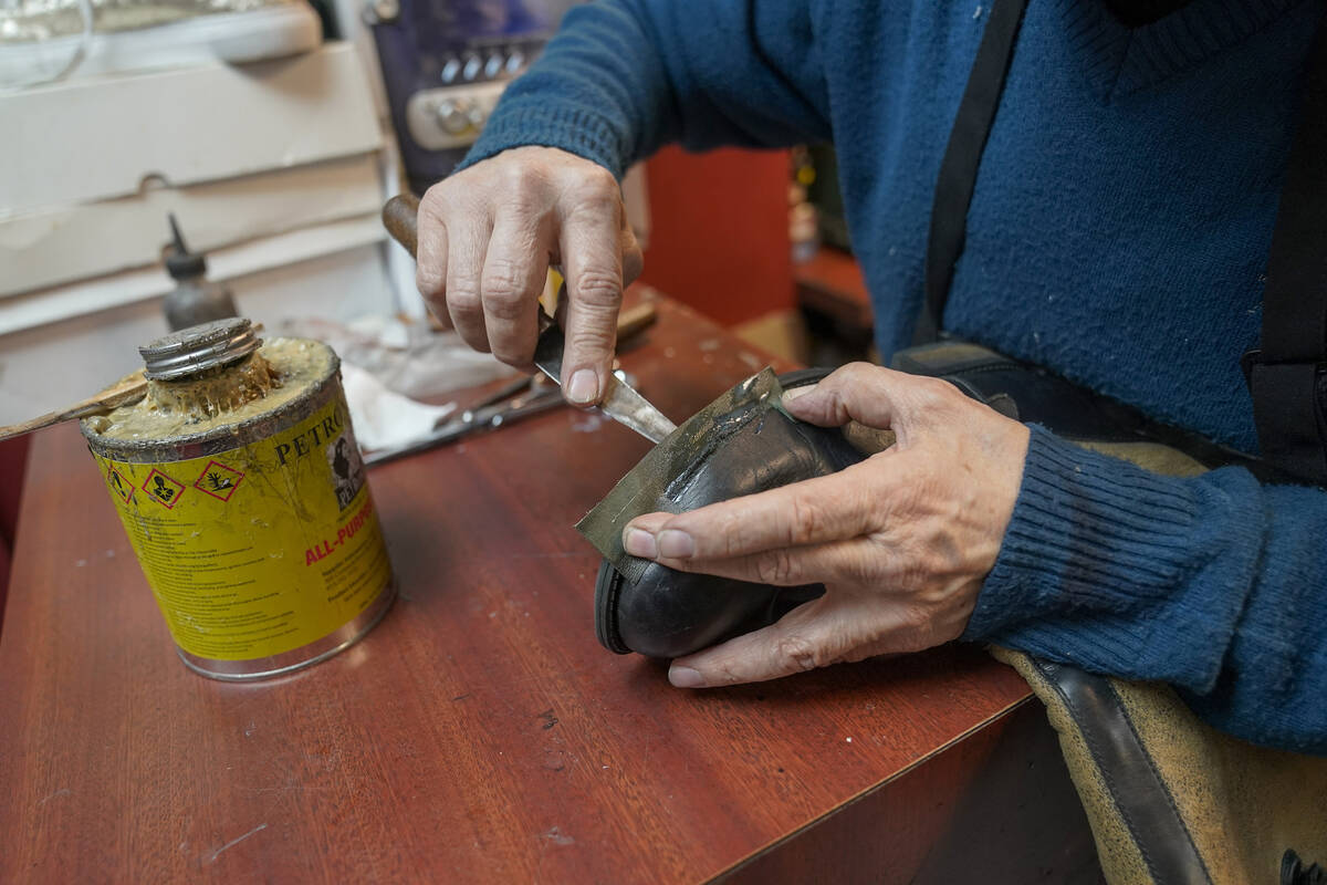 Jairo Cardenas, the owner the Alpha Shoe Repair Corp., repairs a boot, Friday, Feb. 3, 2023, in ...