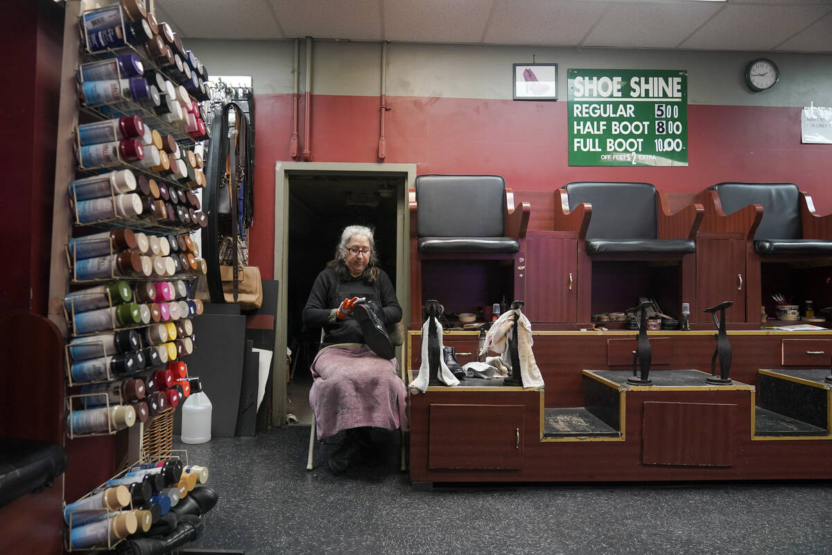 Bertha Gomez shines a shoe while waiting for customers at the Alpha Shoe Repair Corp., Friday, ...