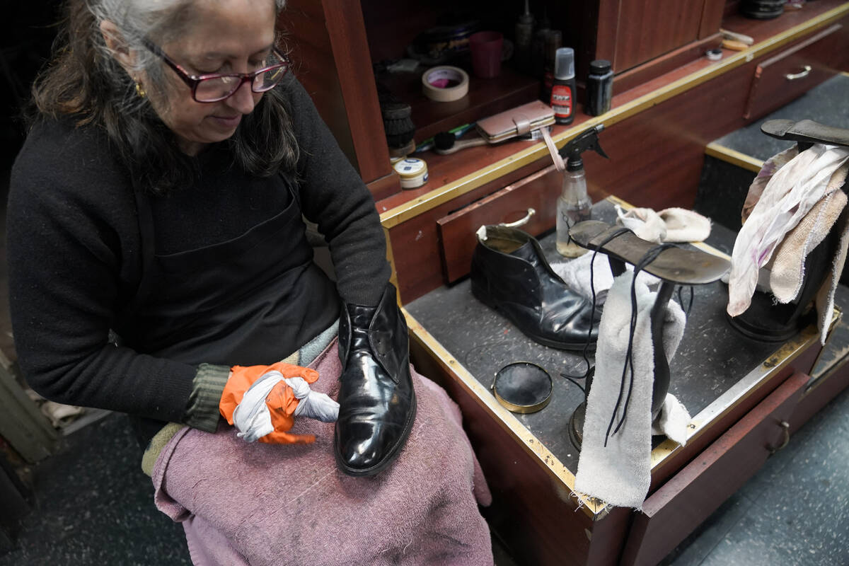 Bertha Gomez shines a customer's shoe at the Alpha Shoe Repair Corp., Friday, Feb. 3, 2023, in ...