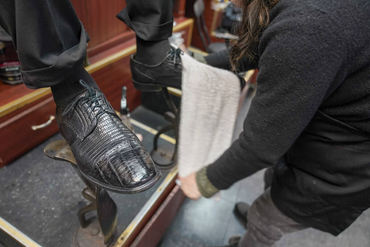 Bertha Gomez shines a customer's shoes at the Alpha Shoe Repair Corp., Friday, Feb. 3, 2023, in ...