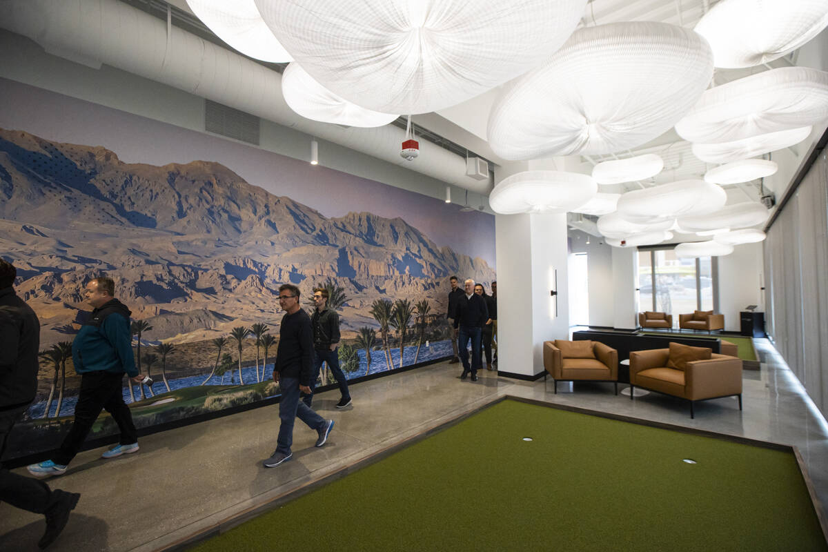People walk through a room featuring PuttView during a tour of DraftKings' new offices at UnCom ...