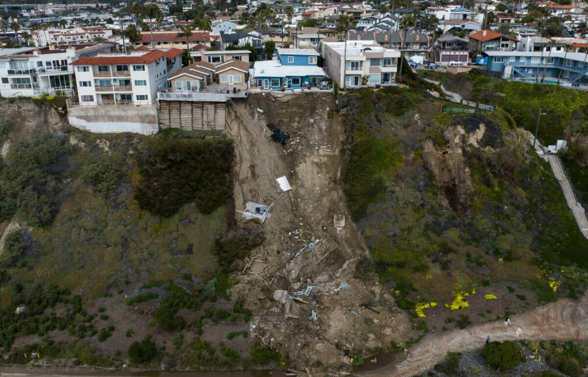 In this image taken with a drone, a residential swimming pool hangs on a cliffside after a land ...