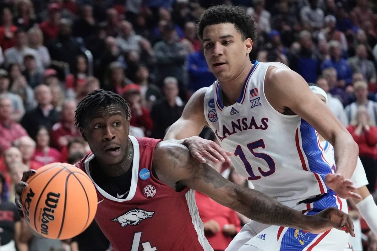 Arkansas' Davonte Davis drives by Kansas' Kevin McCullar Jr. during the second half of a second ...