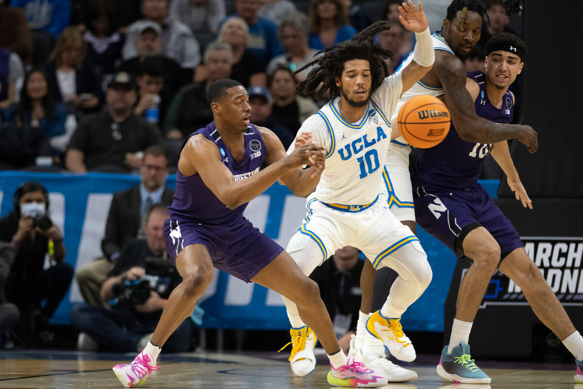 Northwestern guard Chase Audige, left, loses control of the ball as UCLA guard Tyger Campbell ( ...