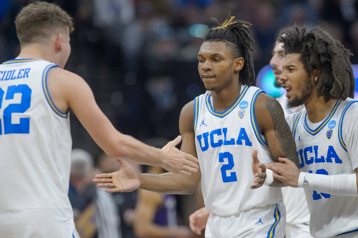 UCLA guard Jack Seidler, left, congratulates guard Dylan Andrews (2) and guard Tyger Campbell a ...