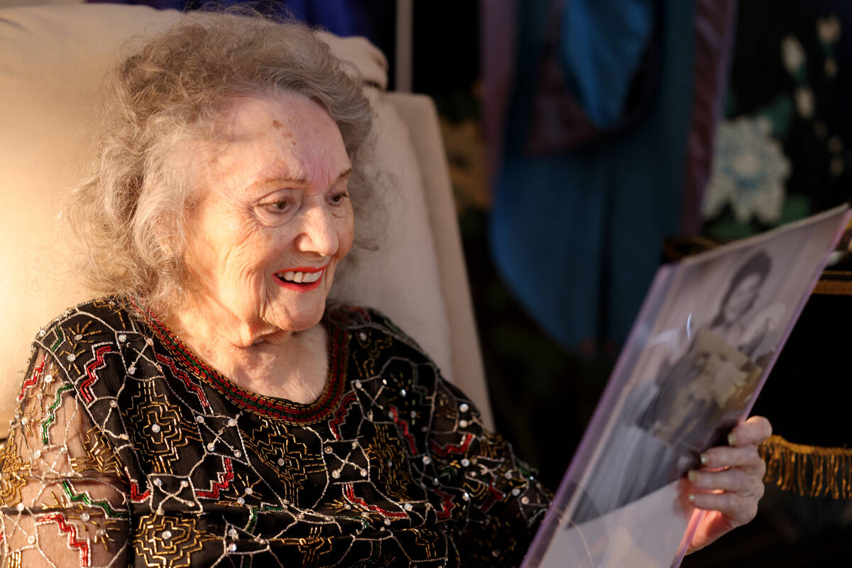 Magician Gloria Dea, 99, looks at old photos at her Las Vegas home Tuesday, Aug. 9, 2022. Dea w ...