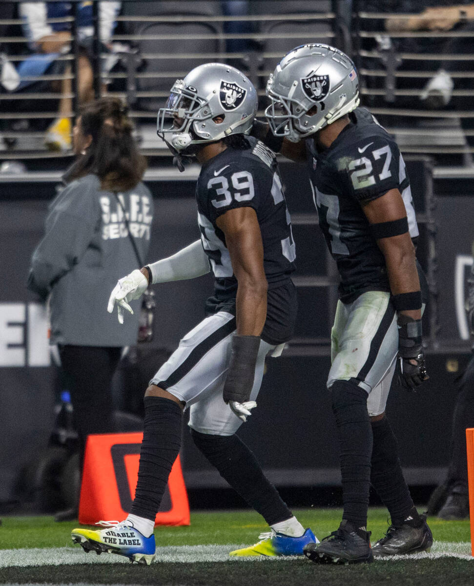 Raiders cornerback Nate Hobbs (39) and cornerback Sam Webb (27) celebrate a play defended durin ...