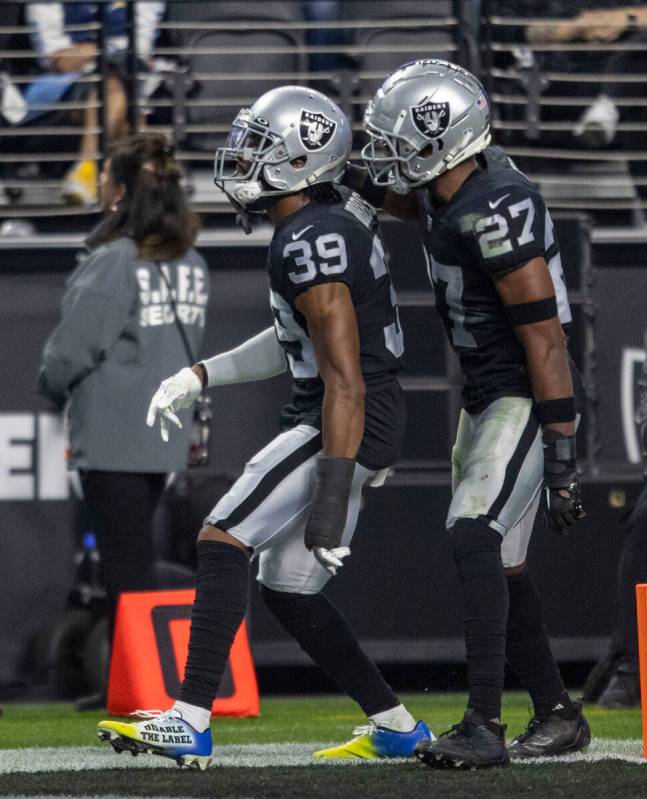 Raiders cornerback Nate Hobbs (39) and cornerback Sam Webb (27) celebrate a play defended durin ...