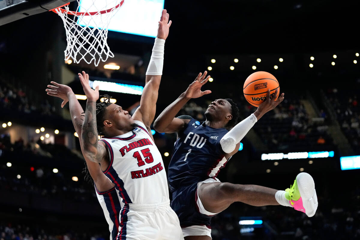 Fairleigh Dickinson guard Joe Munden Jr. (1) drives on Florida Atlantic guard Alijah Martin (15 ...