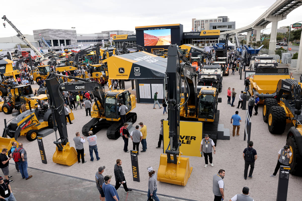 Conventioneers check out products in the John Deere booth at the Las Vegas Convention Center on ...