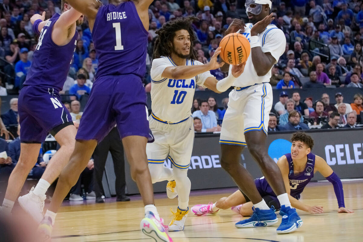 UCLA guard Tyger Campbell (10) passes the ball past Northwestern guard Chase Audige (1) during ...