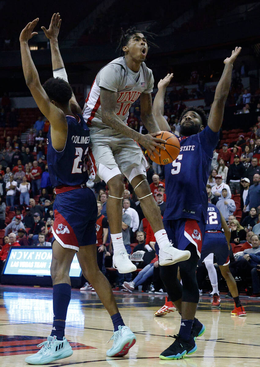 UNLV Rebels guard Keshon Gilbert (10) jumps to shoot as Fresno State Bulldogs guard Leo Colimer ...