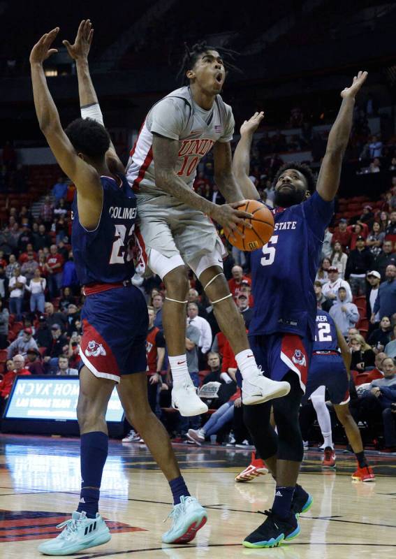 UNLV Rebels guard Keshon Gilbert (10) jumps to shoot as Fresno State Bulldogs guard Leo Colimer ...