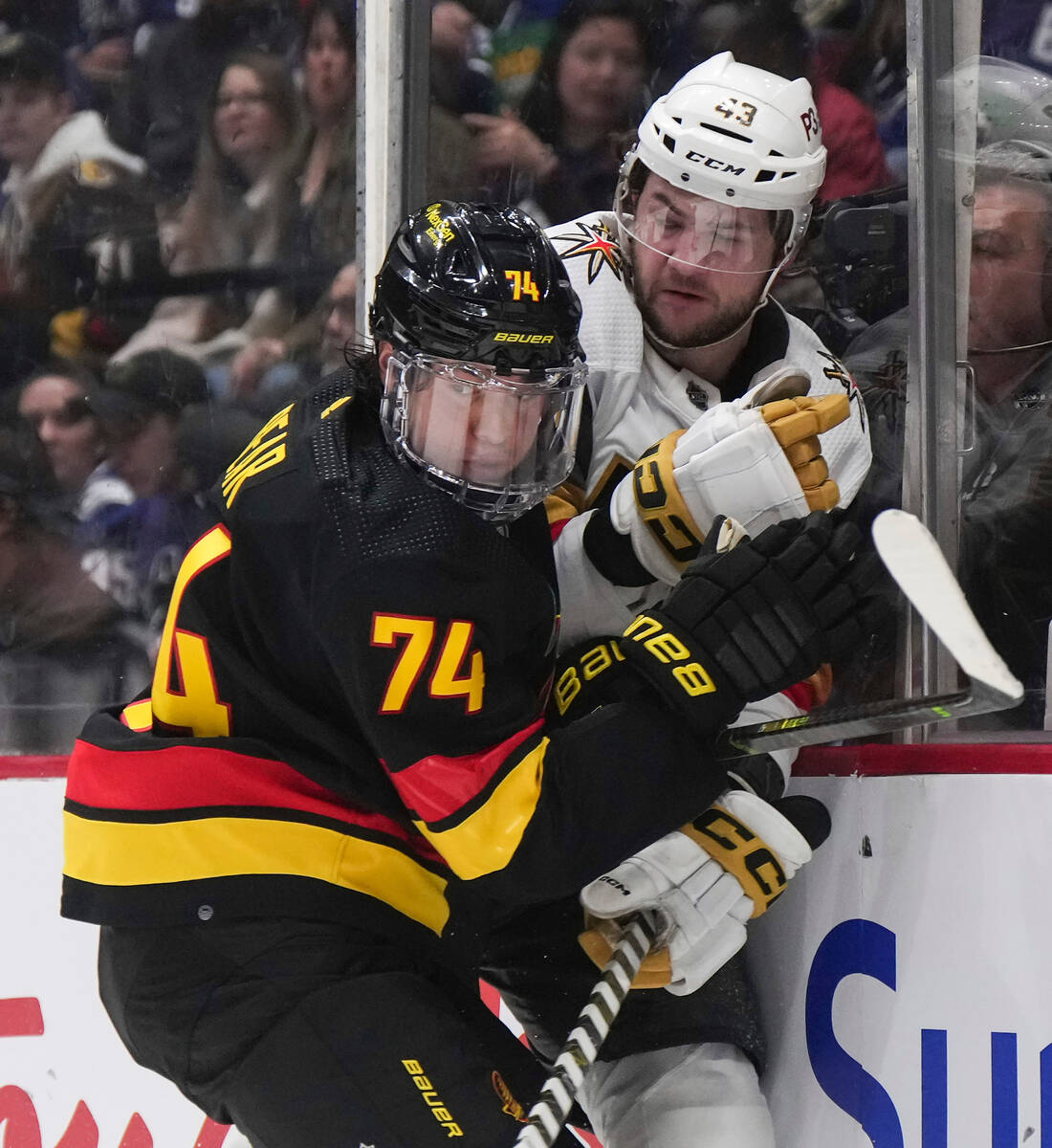Vancouver Canucks' Ethan Bear, left, checks Vegas Golden Knights' Paul Cotter during the first ...
