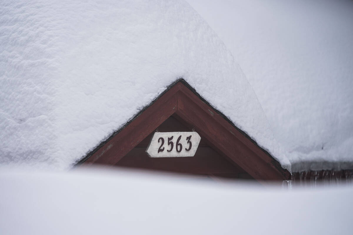 Snow is piled up on a home in Running Springs, Calif., Tuesday, Feb. 28, 2023. (AP Photo/Jae C. ...