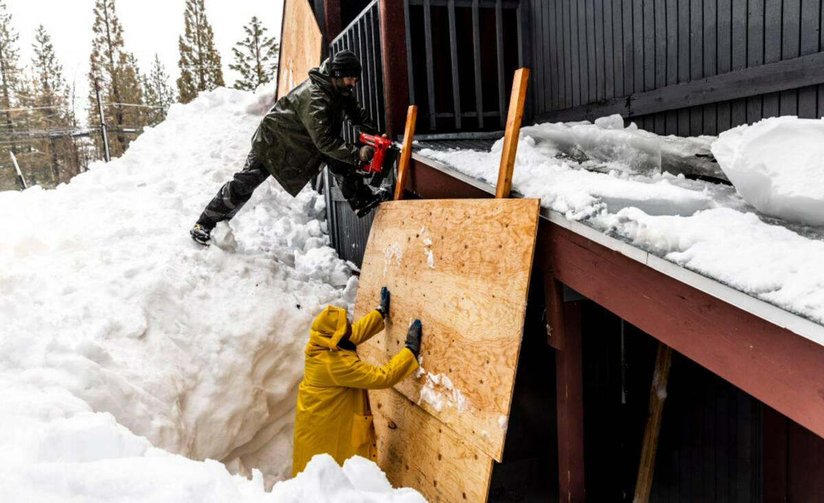 Steven Kirk, owner of Eagle Bear Construction, above, and Roberto Martinez install a sheathing ...