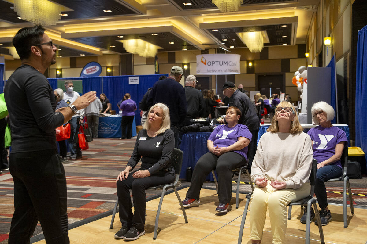 Attendees of the Aging Wellness Expo participate in Yoga for Trauma with instructor Jonathan Ji ...