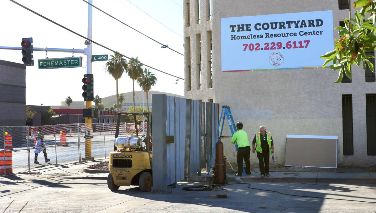 Workers install a gate at the corner of Las Vegas Boulevard and Foremaster Lane near the Courty ...