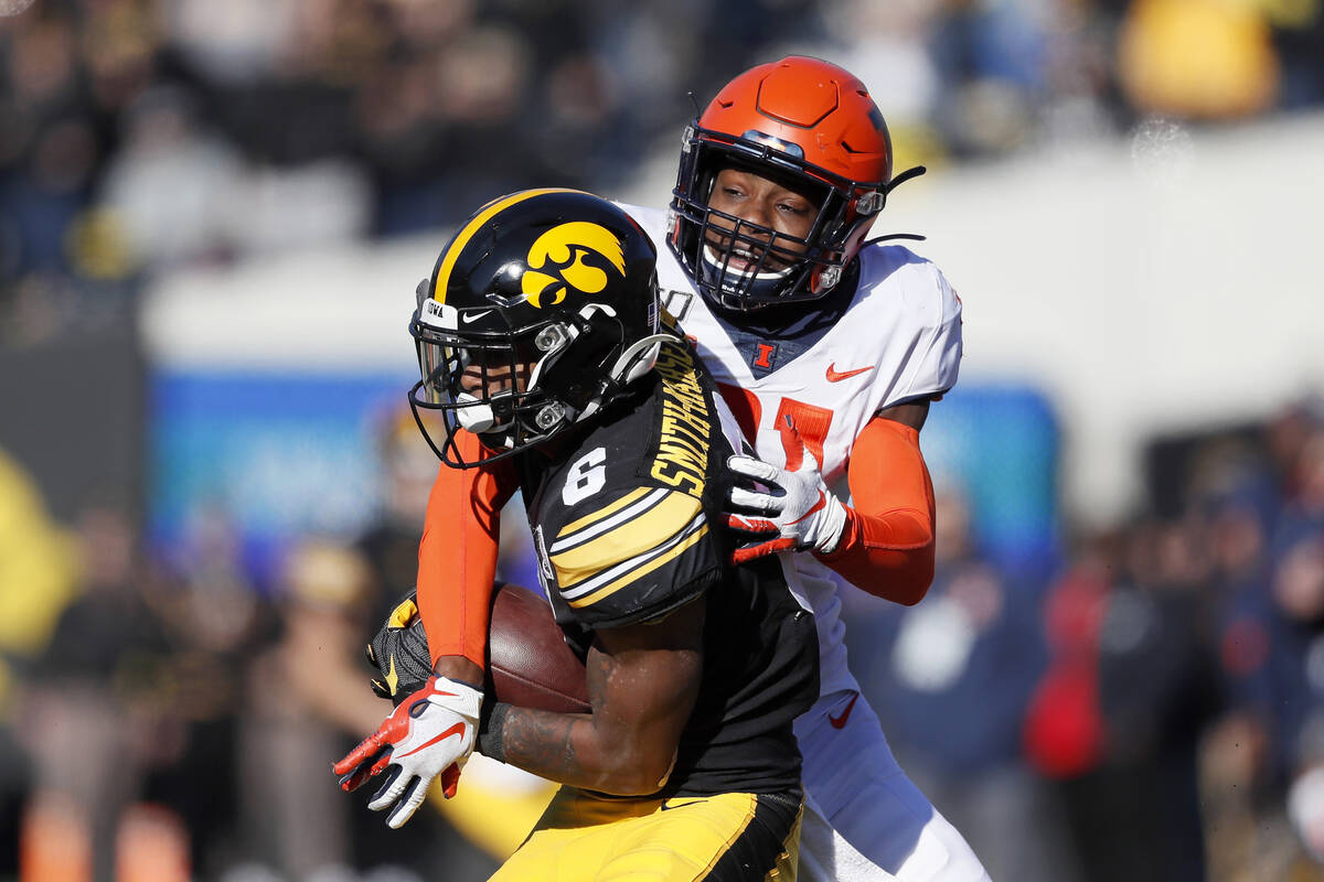 Iowa wide receiver Ihmir Smith-Marsette, left, catches a pass in front of Illinois defensive ba ...