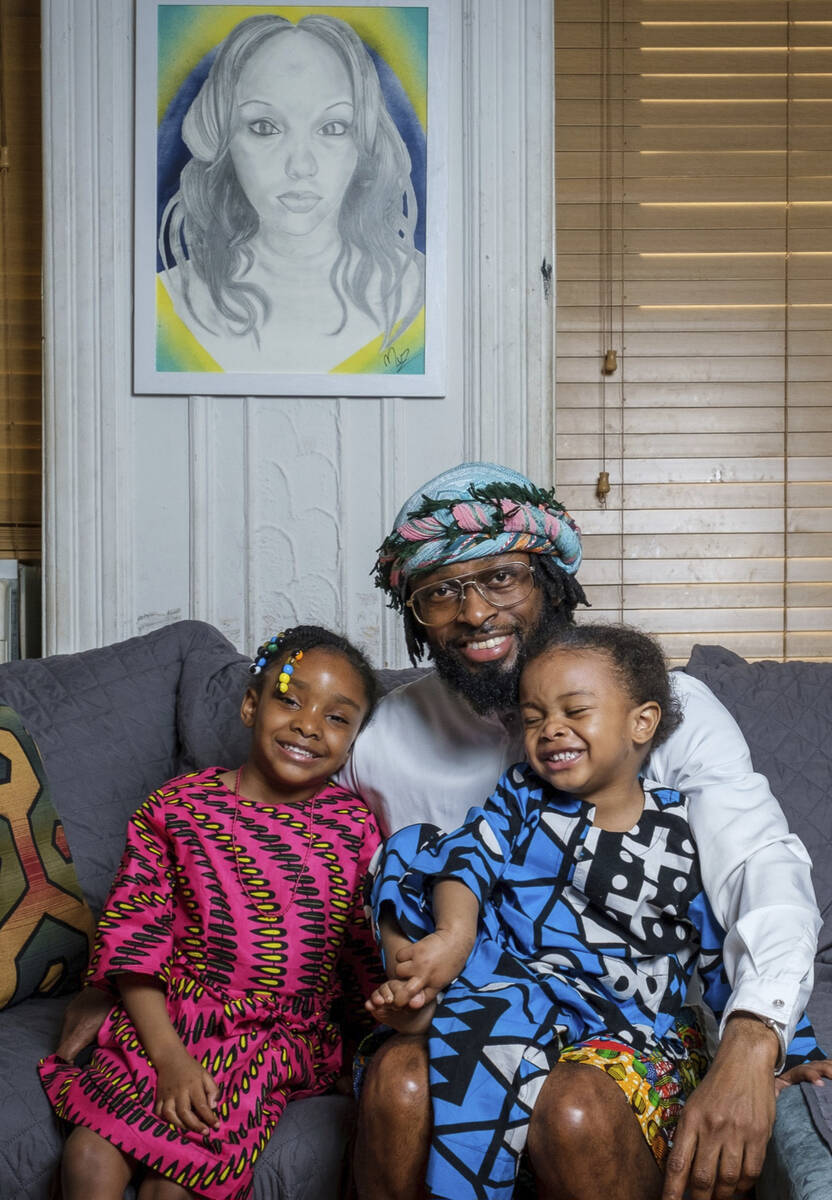 In this photo provided by Henry Danner, Omari Maynard sits with his children, Anari, left, and ...