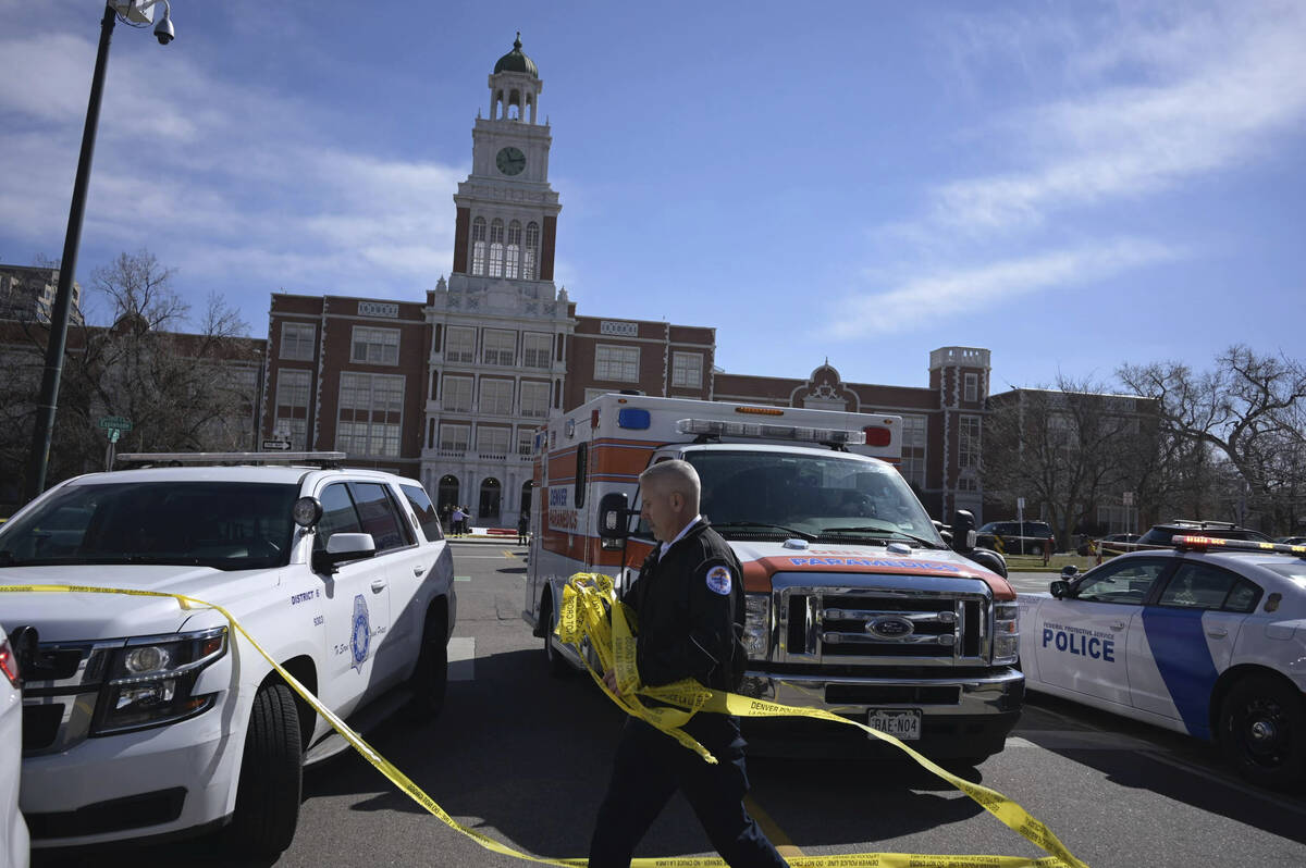 Emergency personnel remove police tape outside East High School after a school shooting, Wednes ...