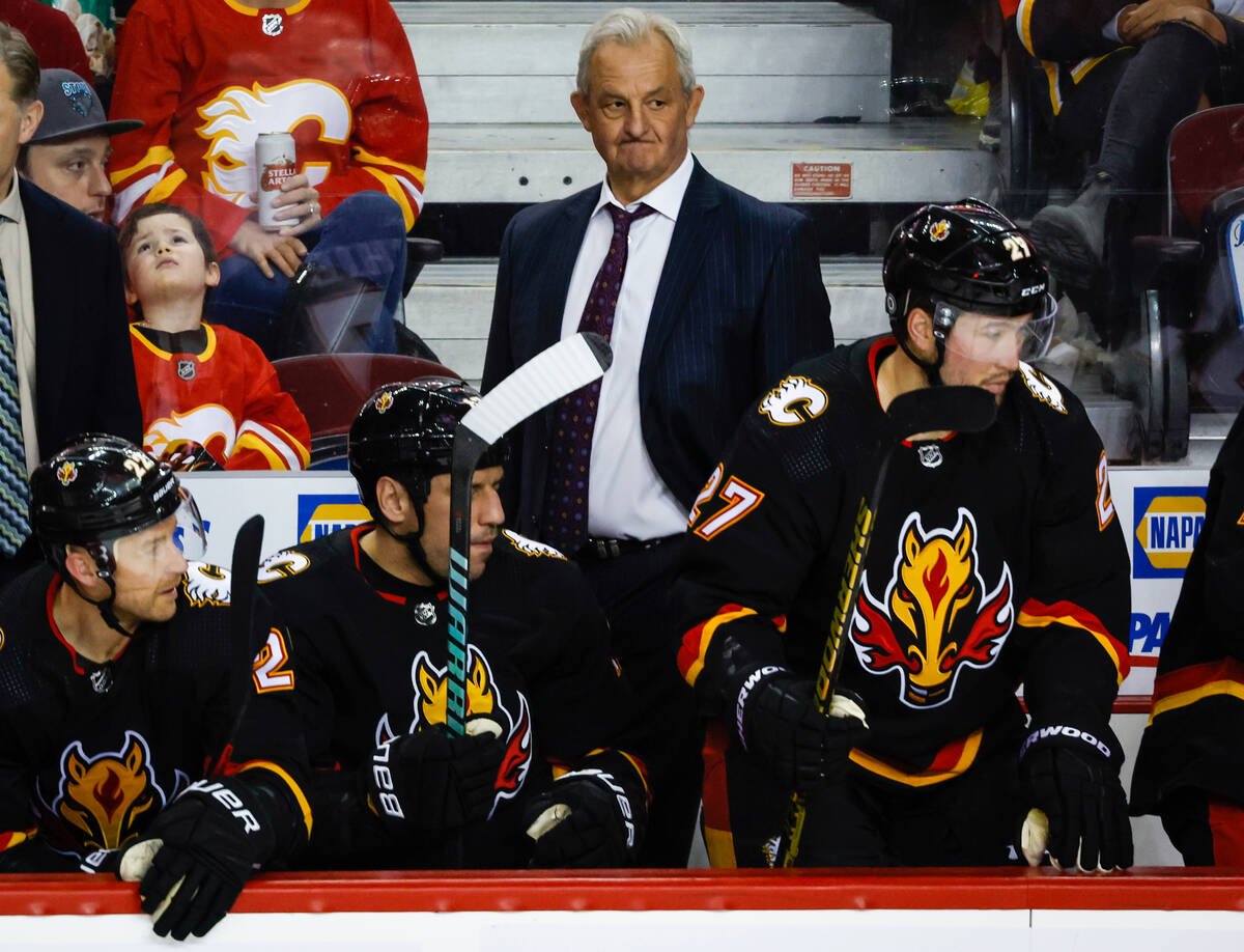 Calgary Flames head coach Darryl Sutter, center, watches the play during third-period NHL hocke ...