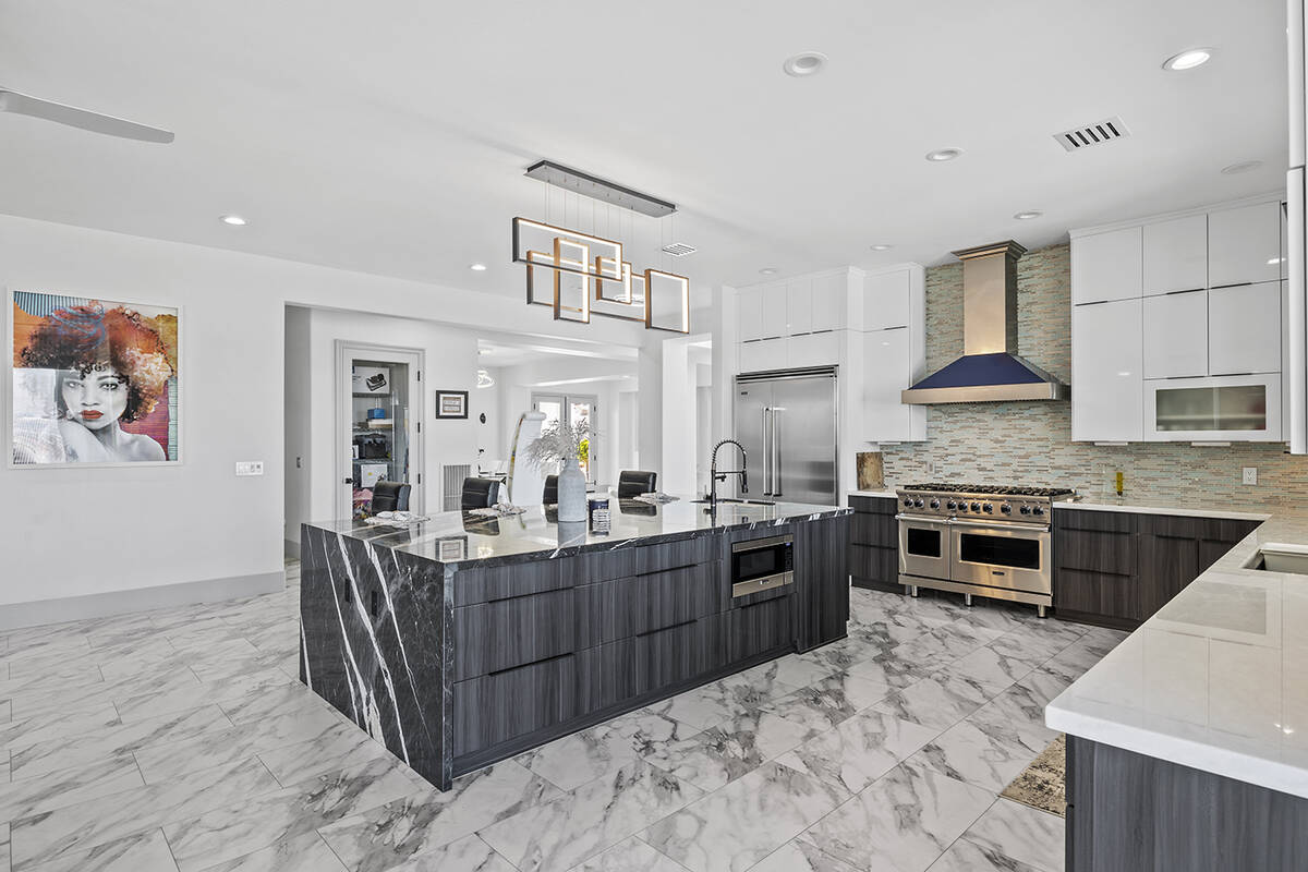 The redesigned kitchen space features European custom two-tone cabinetry, a 10-foot central isl ...