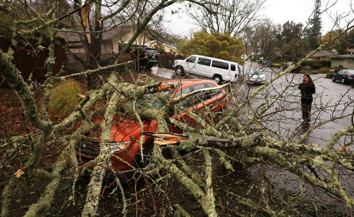 Amber Balog surveys the damage to a friend's vehicle, Tuesday, March 21, 2023, after a saturate ...