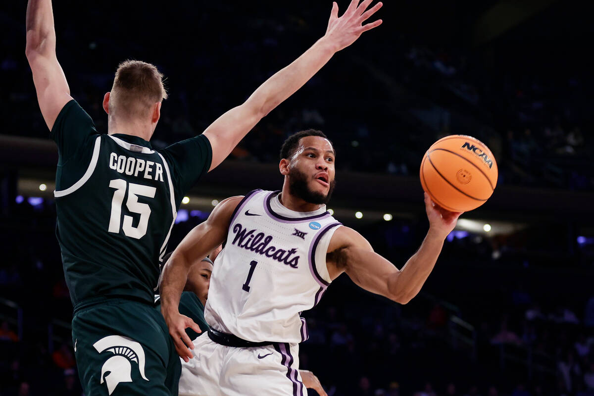 Kansas State guard Markquis Nowell (1) passes as Michigan State center Carson Cooper (15) defen ...