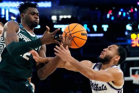Michigan State center Mady Sissoko (22) and Kansas State guard Markquis Nowell (1) reach for th ...