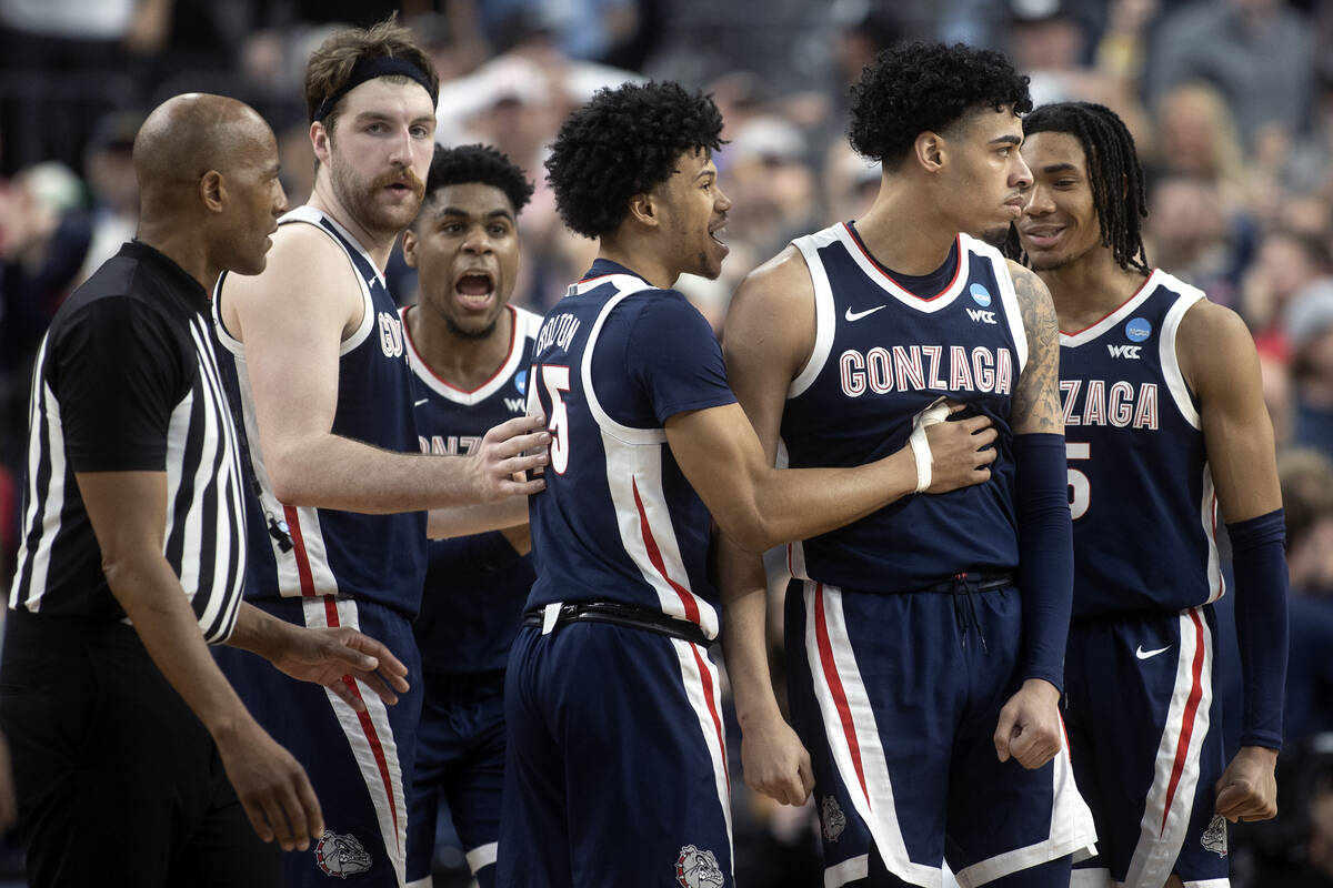 The Gonzaga Bulldogs surround guard Julian Strawther (0) after he scored a late three-pointer d ...