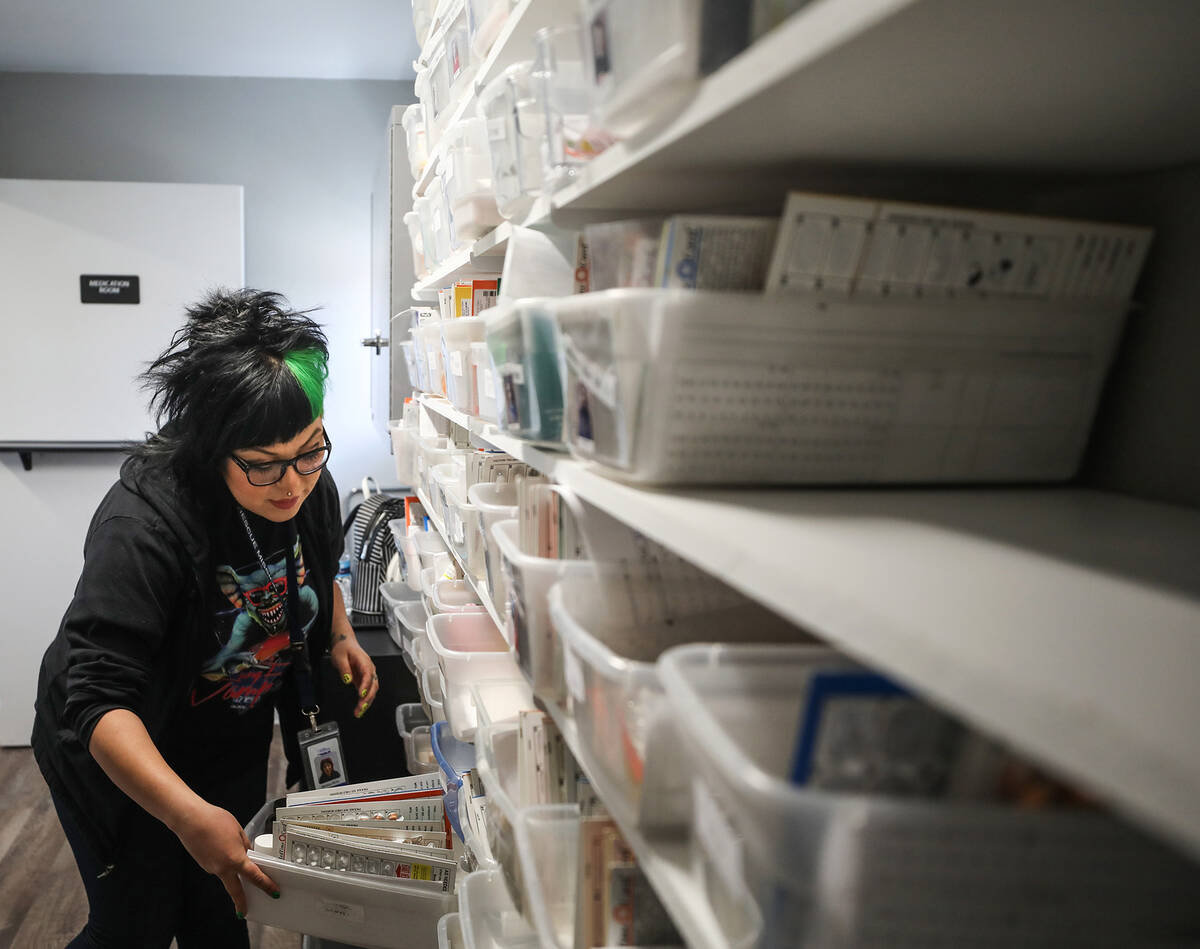 Monica Real, a case worker with the Las Vegas Rescue Mission, picks medicine off the shelf for ...