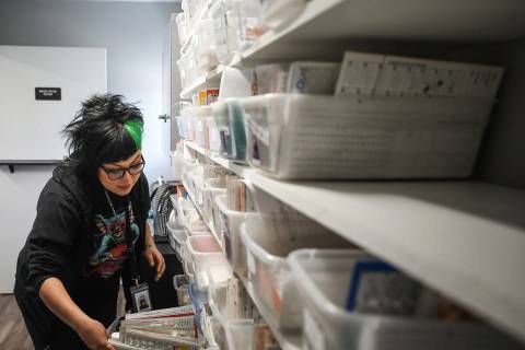 Monica Real, a case worker with the Las Vegas Rescue Mission, picks medicine off the shelf for ...