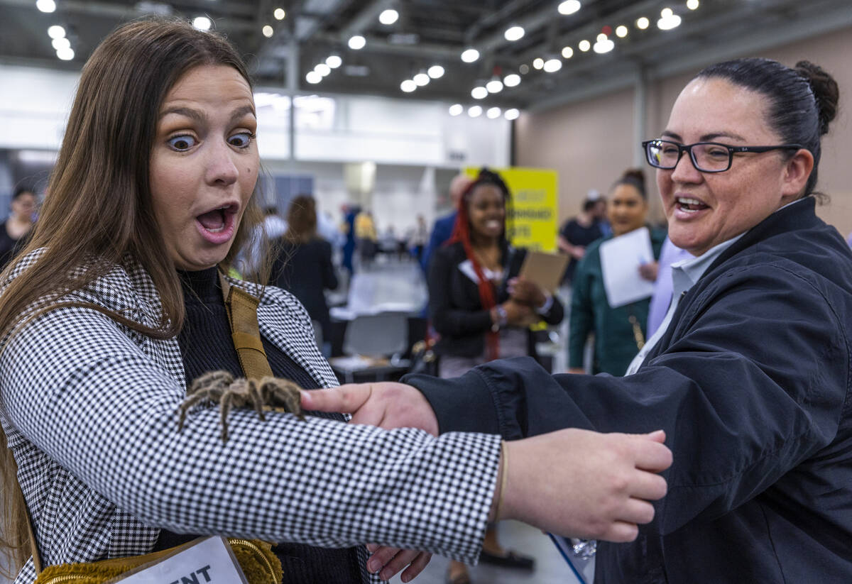 Jalyn Yochum, left, reacts Chile the tarantula on her arm from a booth by Preventive Pest Contr ...