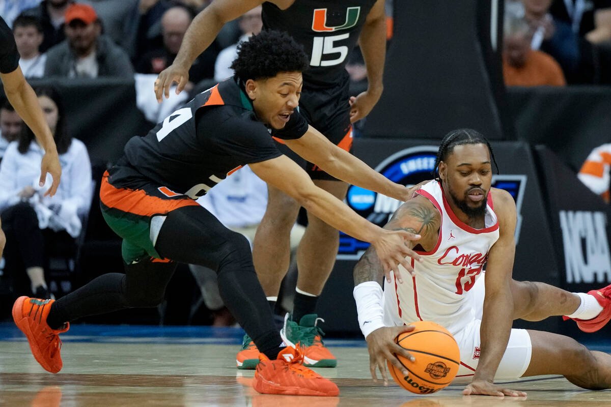 Miami guard Nijel Pack and Houston forward J'Wan Roberts vie for the ball in the first half of ...