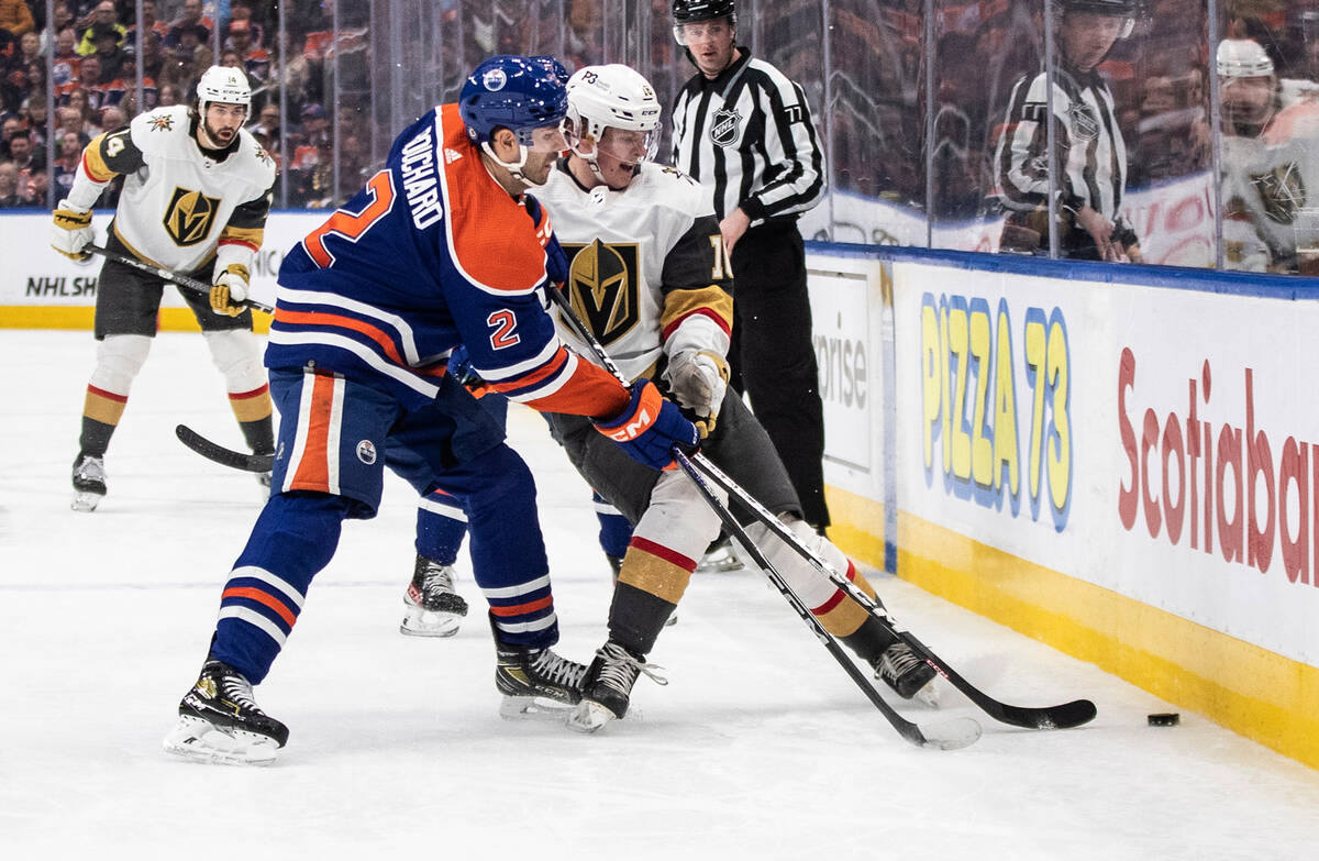 Vegas Golden Knights' Pavel Dorofeyev (16) and Edmonton Oilers' Evan Bouchard (2) compete for t ...